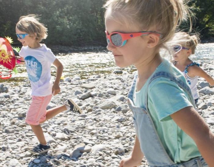 Campagnes 2019 pour les lunettes Julbo pour enfants, au bord d'une rivière en train de jouer sur les galets