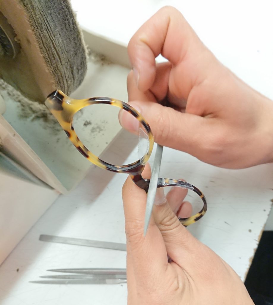 Frédéric, artisan opticien, lime des lunettes en écaille pour ajuster parfaitement à la morphologie du porteur afin d'illustrer l'art de la belle lunetterie