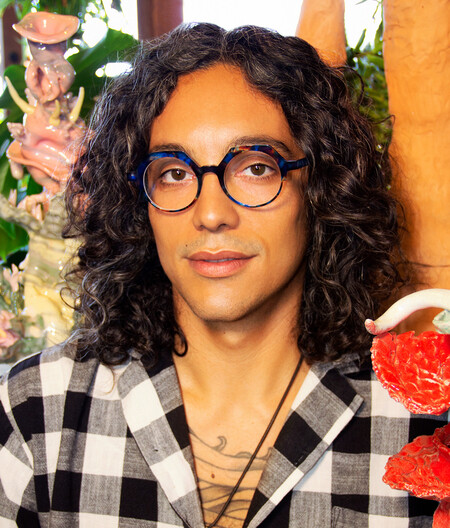 L.A. EYEWORKS un hommes aux cheveux longs et bouclés portes de jolies lunettes rondes bleues de la marque LA Eyeworks