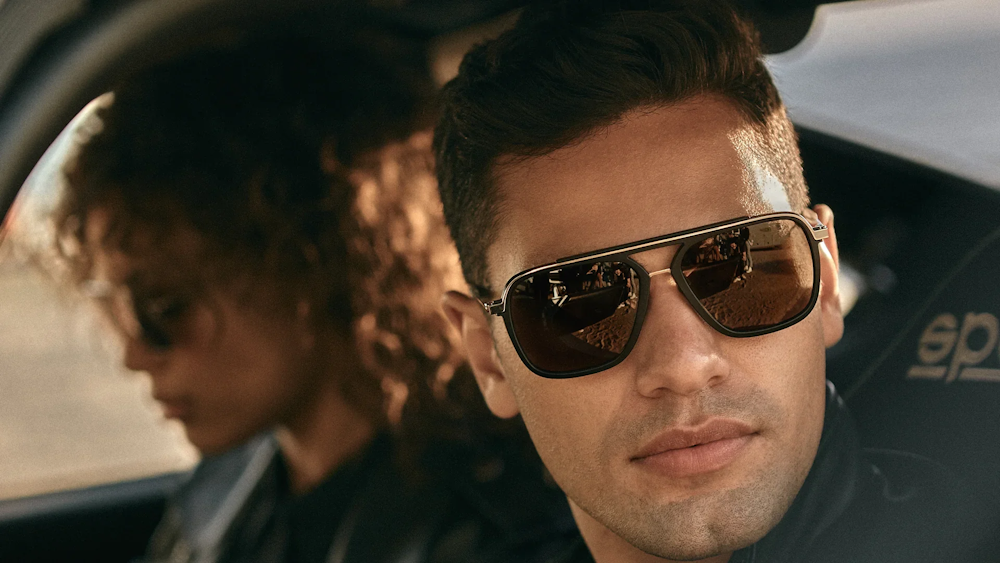 Homme portant des lunettes de soleil de la marque Dita Lancier, dans une voiture accompagné par une femme