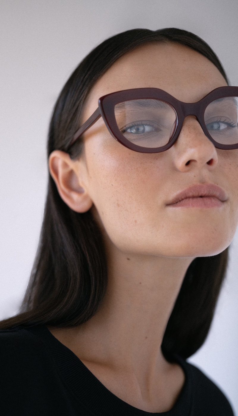 Photo de campagne pour la marque de lunettes Kaleos. Une jeune femme pleine d'assurance porte de jolies lunettes papillon