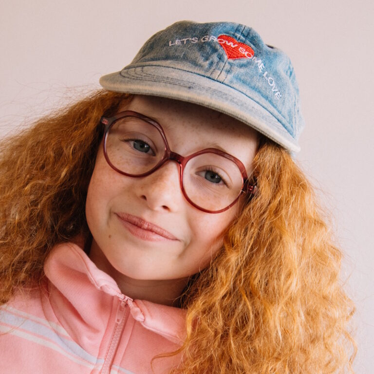Jeune fille rousse au cheveux bouclés porte les nouvelles lunettes enfant de la marque française Roussilhe
