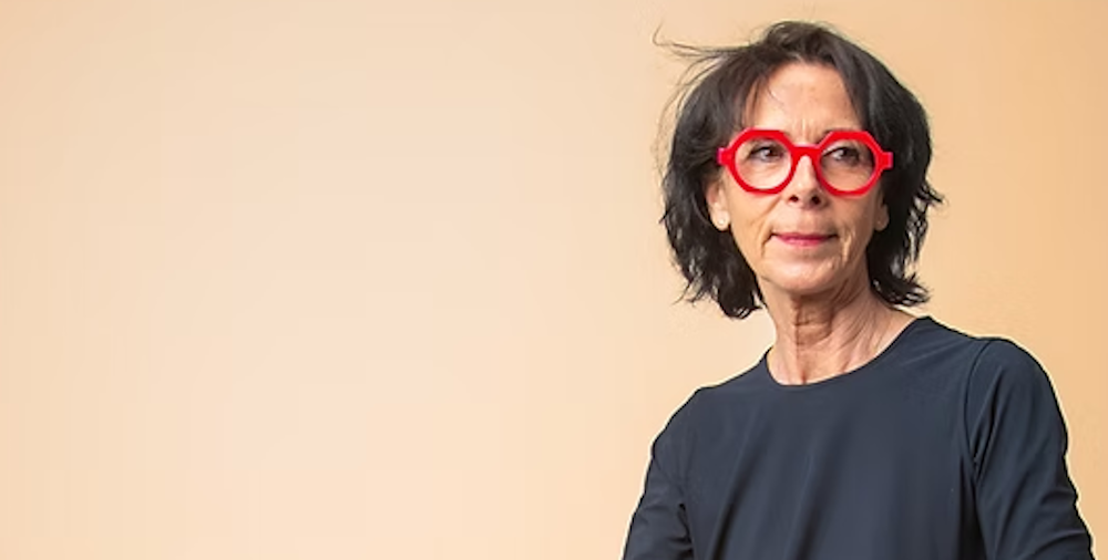 une femme d'une cinquantaine d'année porte des lunettes rouges rondes épaisse de la marque française La brique et la Violette